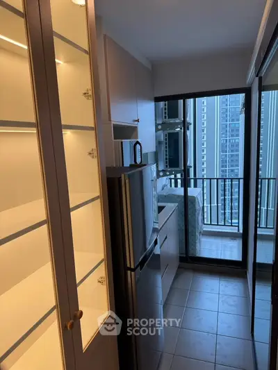 Modern kitchen with sleek appliances and balcony view in high-rise apartment