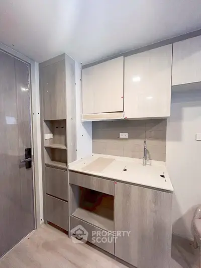 Modern compact kitchen with sleek cabinetry and integrated appliances in a stylish apartment.