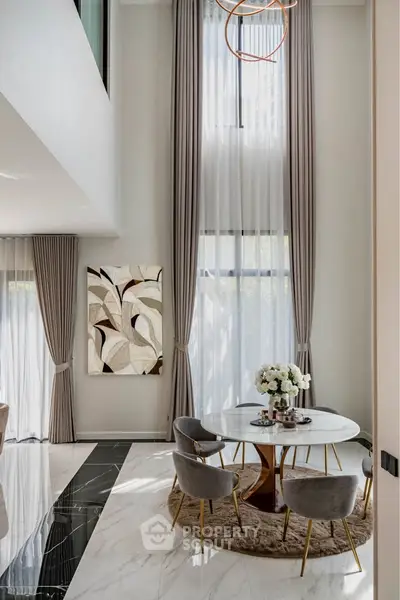 Luxurious high-ceiling living room with elegant decor and tall windows