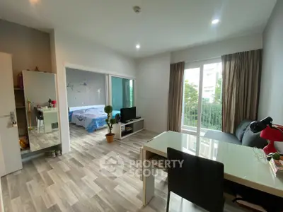 Modern open-plan living room with natural light and view into cozy bedroom