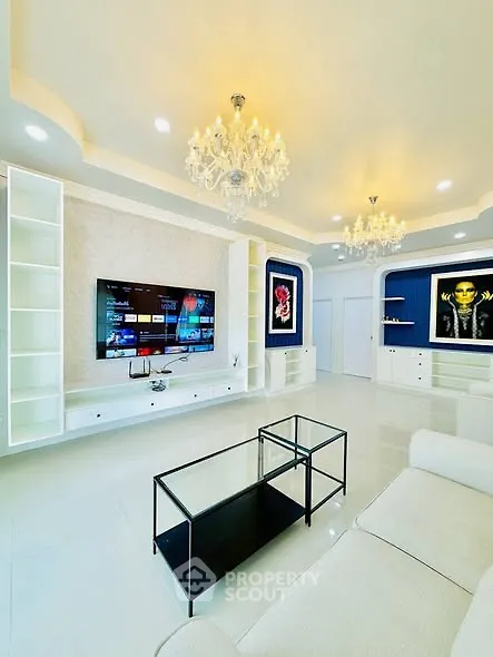 Luxurious living room with elegant chandeliers and modern entertainment setup