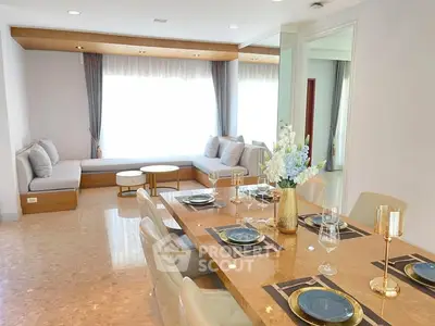 Elegant dining area with luxurious table setting and cozy seating by large window.