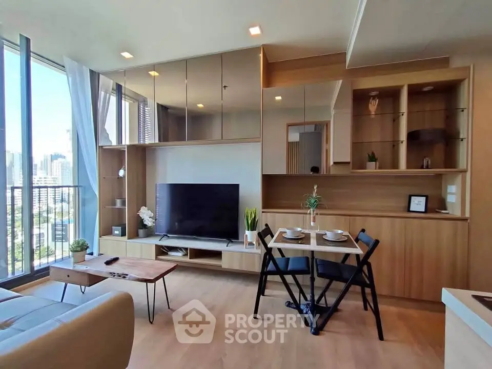 Modern living room with large windows and stylish wooden furniture in a high-rise apartment.