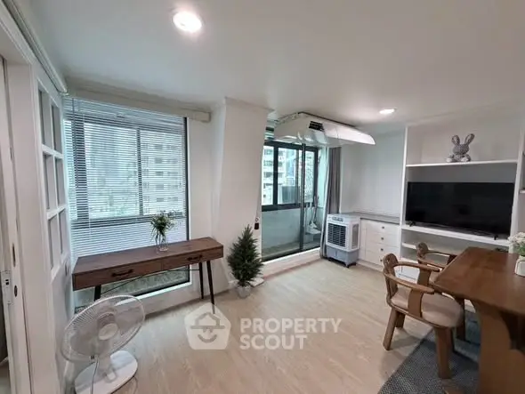 Bright and modern living room with balcony access, featuring stylish furniture and natural light.