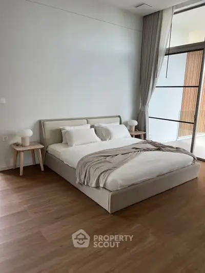 Modern bedroom with elegant decor and large windows for natural light.