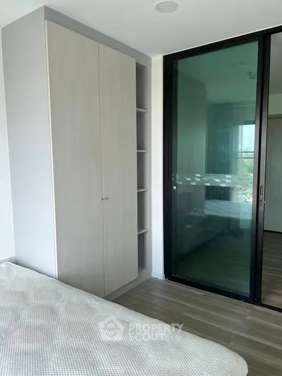 Modern bedroom with sleek wardrobe and large window for natural light