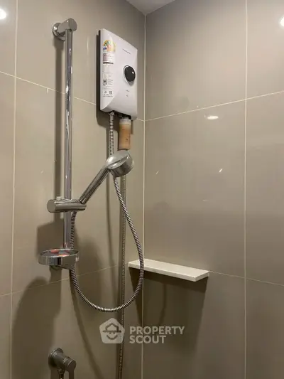 Modern bathroom shower area with sleek fixtures and water heater.