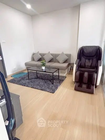 Modern living room with sleek sofa and massage chair on wooden flooring