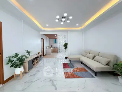 Modern living room with stylish lighting and open layout to kitchen