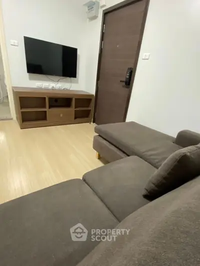 Modern living room with sleek TV setup and comfortable sofa in a stylish apartment.
