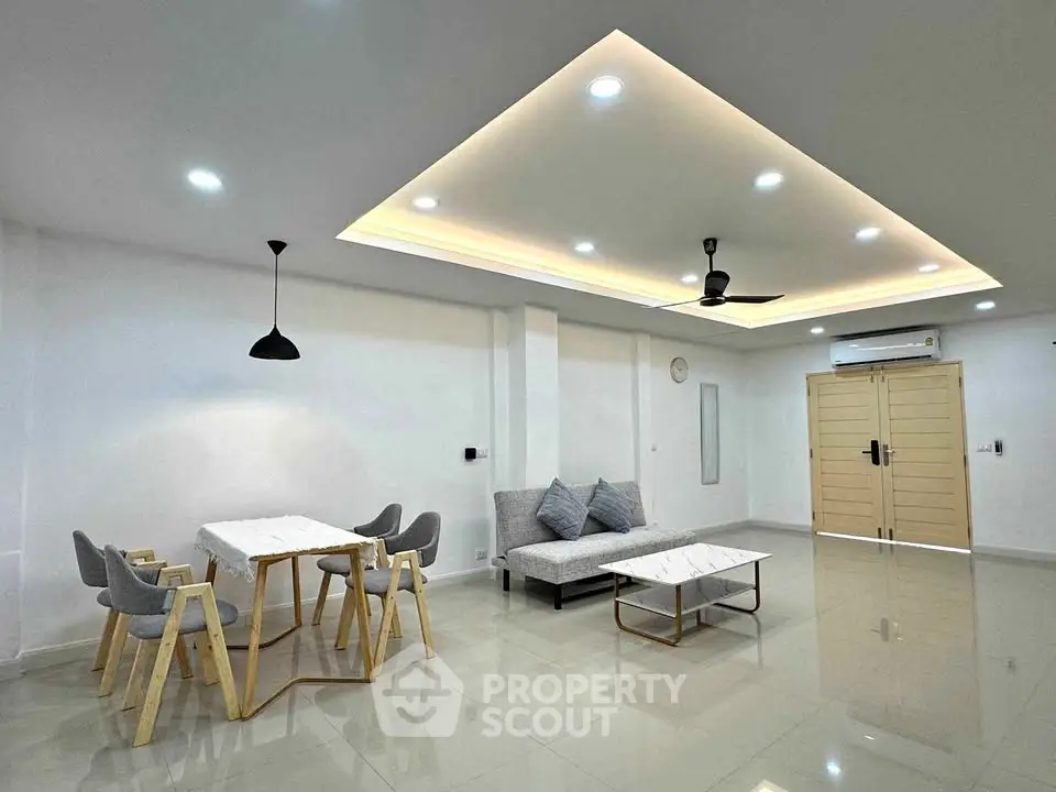 Spacious modern living room with elegant ceiling lights and minimalist furniture
