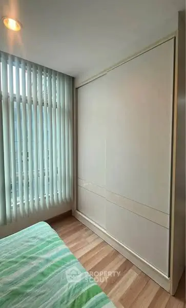 Modern bedroom with large window and sleek wardrobe design