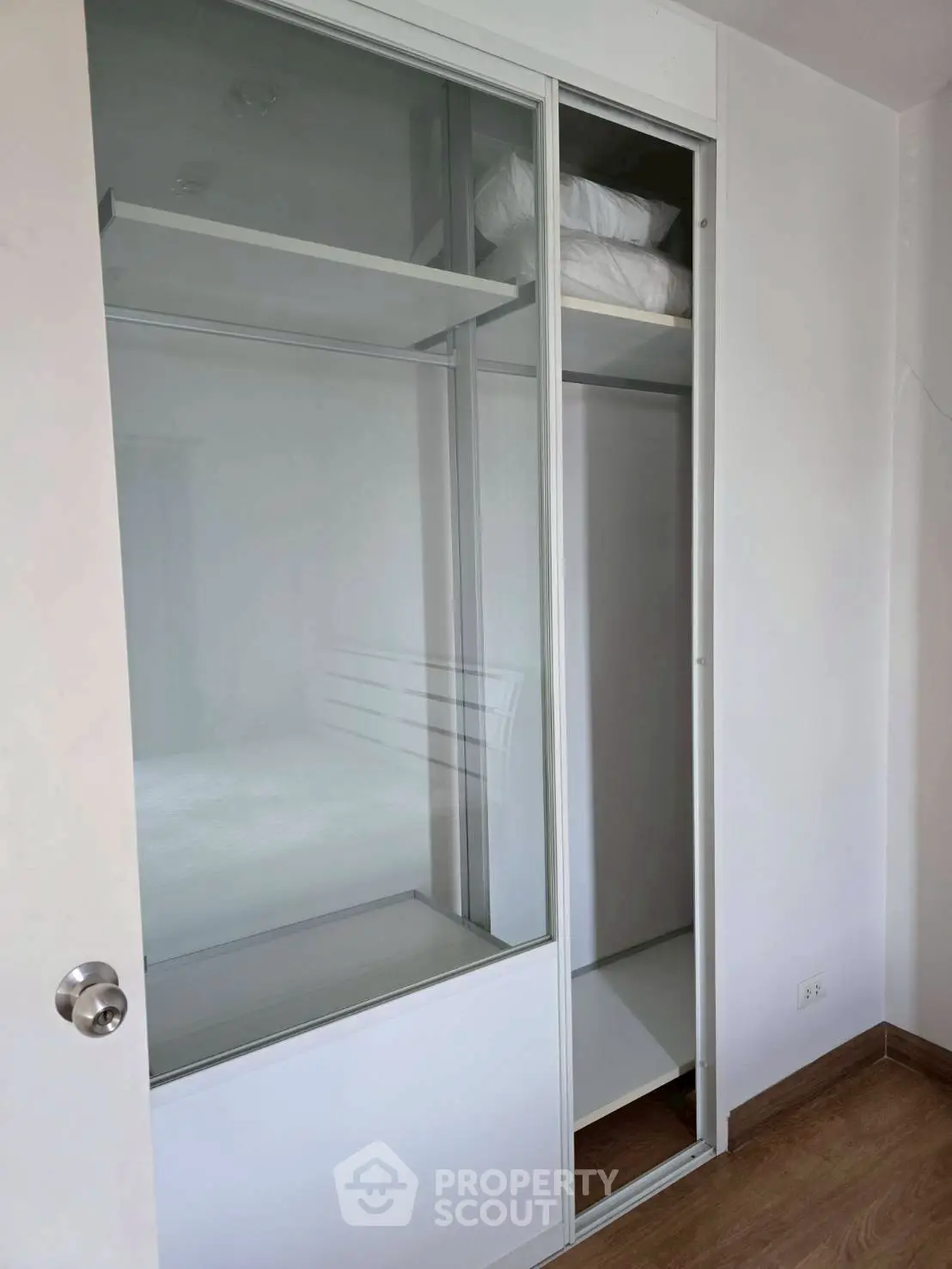 Modern bedroom with sleek sliding closet doors and wooden flooring