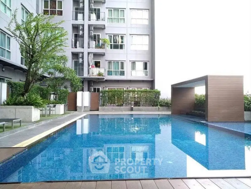 Modern apartment building with a luxurious outdoor pool and stylish cabana area.