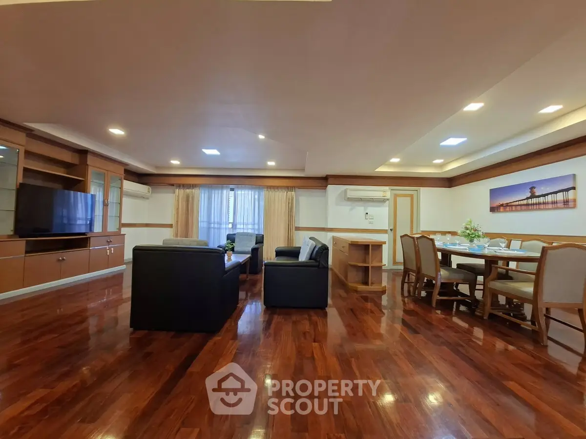 Spacious living room with elegant wooden flooring and modern furniture in a luxurious apartment.
