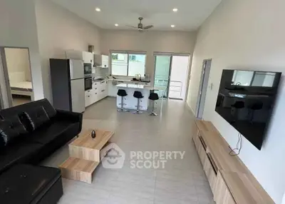 Modern open-plan living room with sleek kitchen and stylish furniture