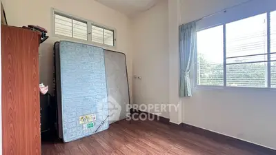 Spacious empty room with large windows and wooden flooring, perfect for customization.