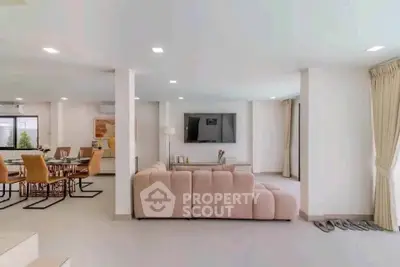 Spacious modern living room with elegant dining area and large sofa, perfect for entertaining.