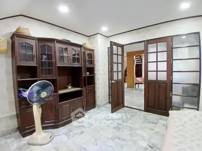 Charming living room with elegant wooden cabinets and marble flooring