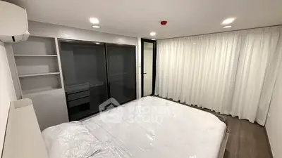 Spacious modern bedroom with large windows and sleek storage solutions.