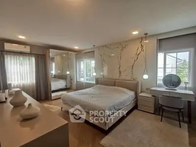Luxurious bedroom with modern decor, large mirror, and elegant lighting in a stylish home.