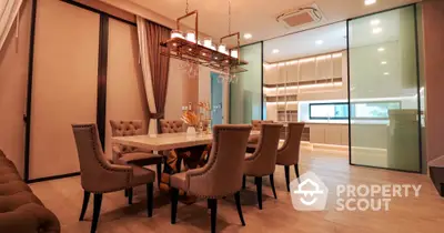 Elegant dining area with modern chandelier, large table, and plush chairs, complemented by warm lighting and sleek flooring, perfect for entertaining.