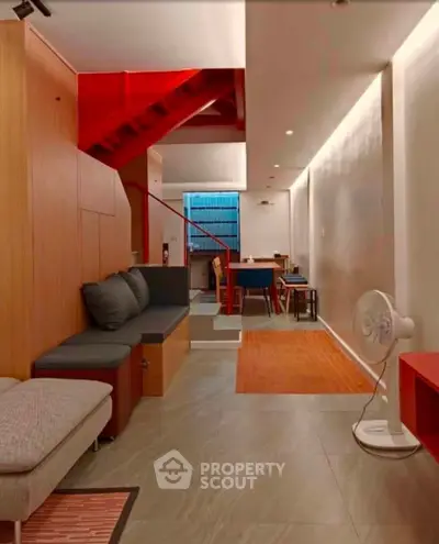 Modern living room with stylish red staircase and cozy seating area