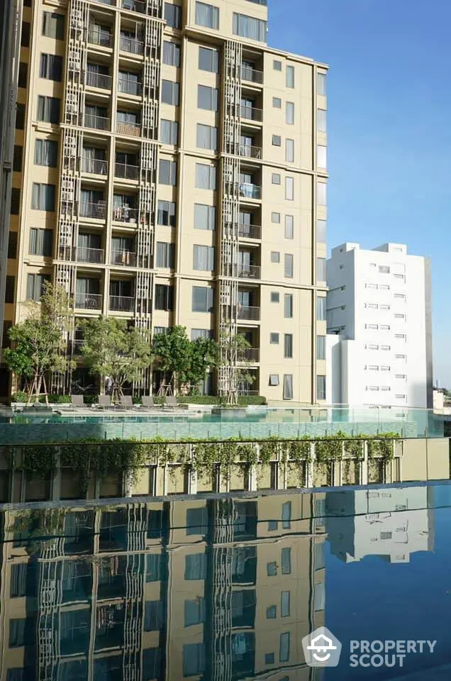 Modern high-rise building with pool reflecting the architecture, offering luxurious urban living.