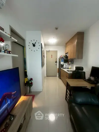 Modern living room with sleek kitchen, stylish decor, and cozy seating area in a compact apartment.