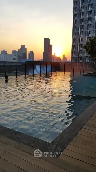 Stunning rooftop pool with city skyline view at sunset, perfect for urban living.
