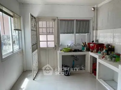 Spacious kitchen with natural light and open layout, featuring modern fixtures and ample storage space.