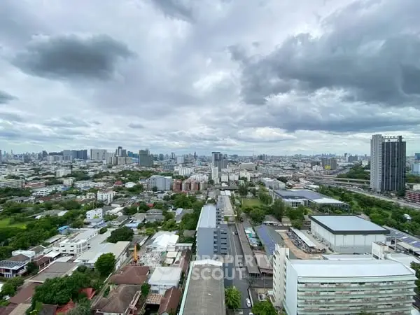 Stunning cityscape view from a high-rise building showcasing urban skyline and greenery.