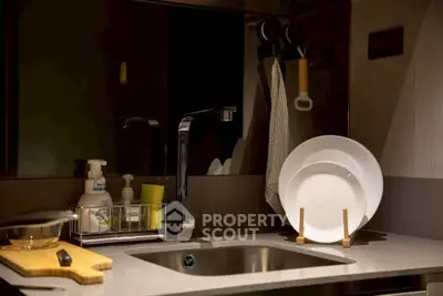 Modern kitchen sink with stylish faucet and dish rack in a cozy apartment setting.