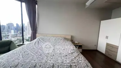 Spacious bedroom with city view in modern high-rise apartment