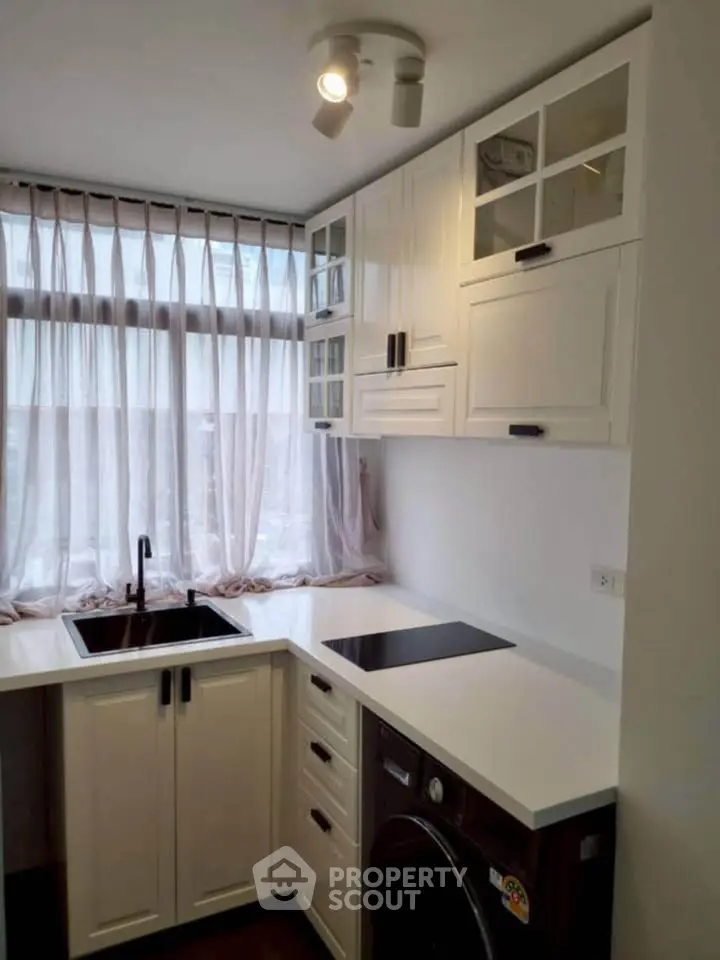 Charming compact kitchen with modern appliances and ample natural light, perfect for efficient cooking and dining.