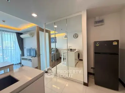 Modern apartment interior with mirrored closet, sleek kitchen, and cozy living area with city view.