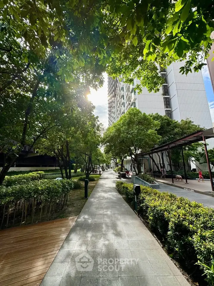 Beautiful garden pathway with lush greenery and modern building view.