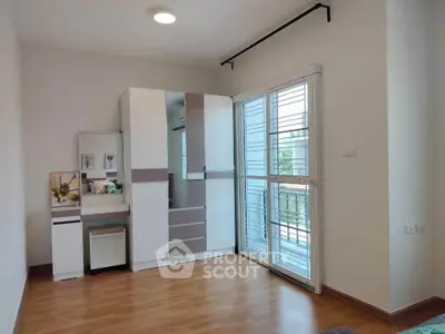 Bright bedroom with modern wardrobe and balcony access in a stylish apartment.