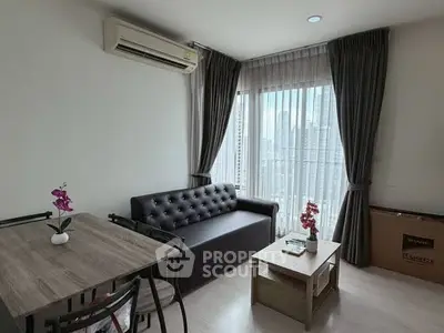 Modern living room with city view, featuring sleek furniture and natural light.