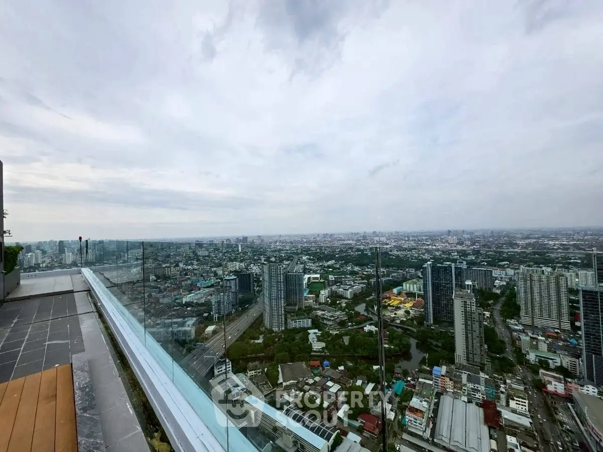 Stunning panoramic city view from a high-rise balcony, showcasing urban skyline and vast horizon.