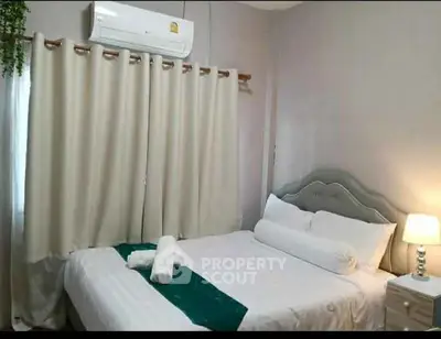 Cozy bedroom with elegant decor and air conditioning, perfect for relaxation.