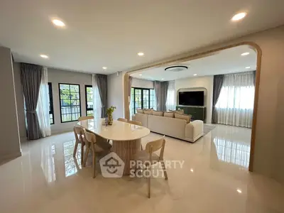 Spacious modern living room with elegant dining area and large windows for natural light.