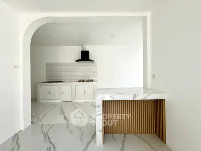 Modern kitchen with marble countertops and sleek white cabinetry