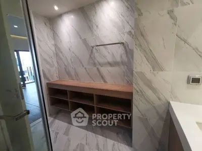 Modern bathroom with sleek marble tiles and wooden storage unit