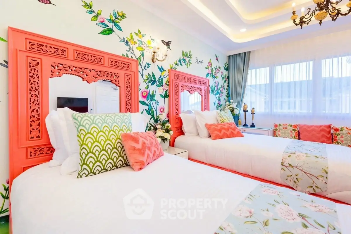 Charming bedroom with vibrant decor and twin beds, featuring floral accents and elegant lighting.
