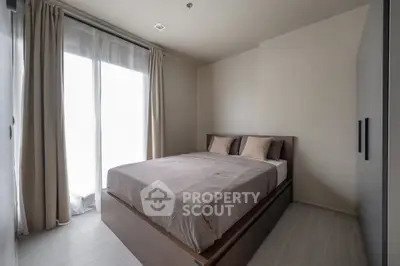 Cozy minimalist bedroom with natural light and modern furnishings.