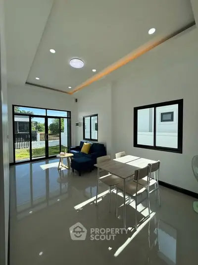 Modern living room with sleek furniture and large windows offering natural light