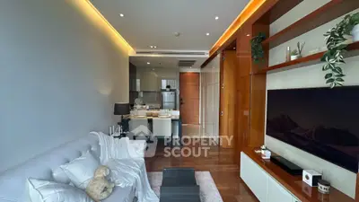 Modern living room with open kitchen, sleek design, and cozy ambiance.