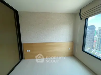 Spacious bedroom with city view in modern high-rise apartment