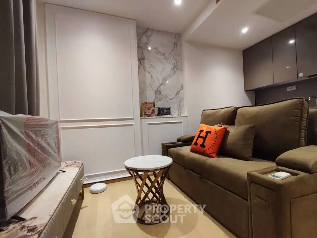 Cozy living room with elegant marble accent wall and plush sofa, perfect for relaxation.